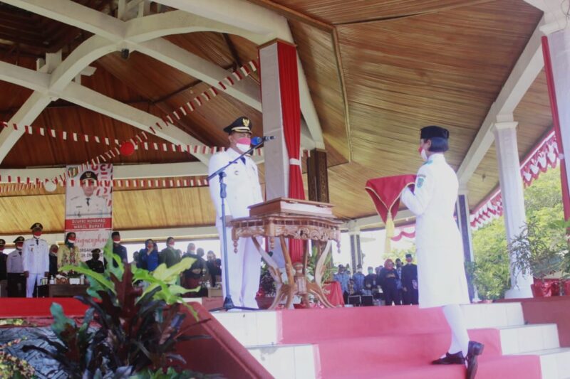 Bupati James saat menyerahkan bendera mereh putih kepada pembawa Baki Pasukan Paskibraka.