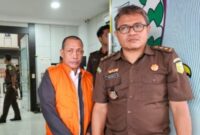 Mantan Kepala Dinas Perkim-Lingkungan Hidup Halmahera Selatan, Ahmad Hadi mengenakan rompi orange (rompi tahanan) ketika digiring keluar menuju mobil tahanan.