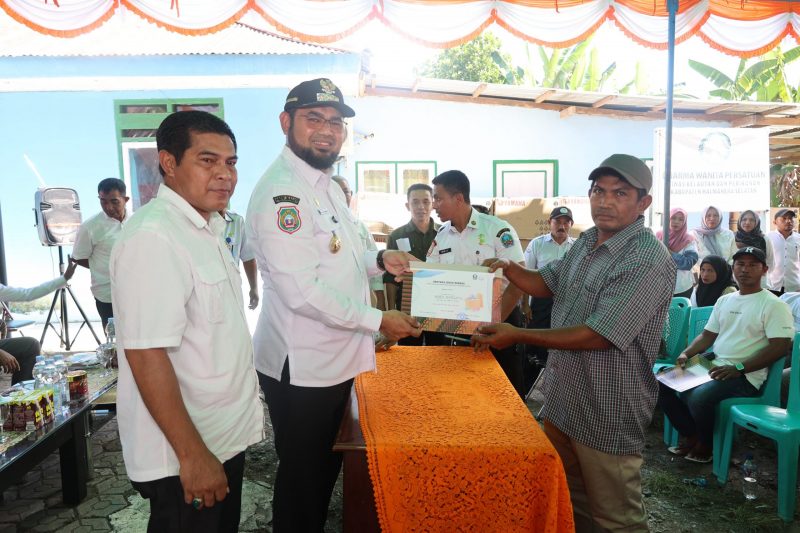 Bupati Hasan Ali Bassam Kasuba saat menyerahkan bantuan secara simbolis kepada perwakilan Kelompok Nelayan, Rabu (21/5/2025$