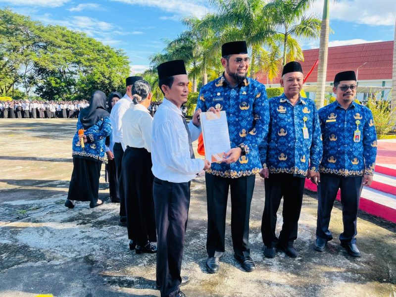 Bupati Hasan Ali Bassam Kasuba di dampingi Sekda Safiun Radjulan dan Kepala BKPPD, Dr. Abdillah Kamarullah saat menyerahkan SK PPPK tahap I di halaman kantor Bupati, Senin (16/6/2025)