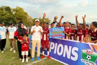 Wakil Bupati Djufri Muhamad didamping Istri saat menyerahkan piala ke tim Kontener FC. (Teluknews)