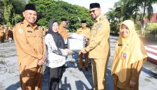Bupati Hasan Ali Bassam Kasuba saat memberikan piagam penghargaan kepada tiga di Guru di halaman kantor Bupati, Senin (24/11/2025).