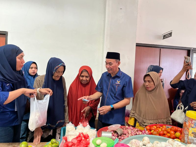 Ketua DPD NasDem Halbar, Djufri Muhamad, saat belanja sembako di Pasar Jailolo.